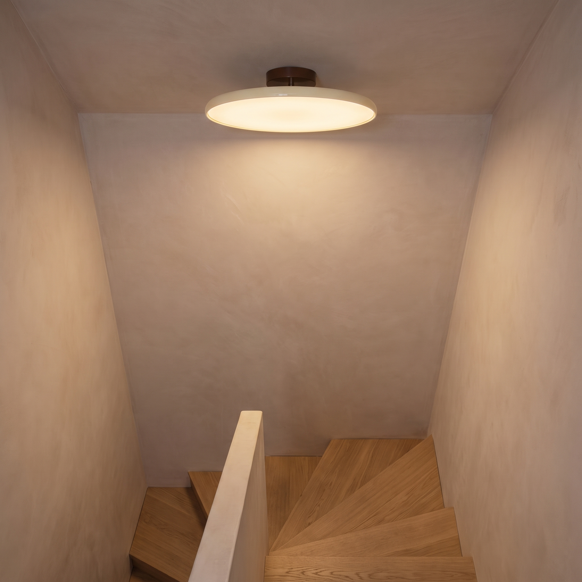 Orbita flush mount light on a sloped ceiling above a stairwell
