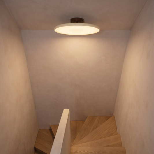 Orbita flush mount light on a sloped ceiling above a stairwell